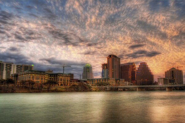 Tall houses by the water on the background of sunset