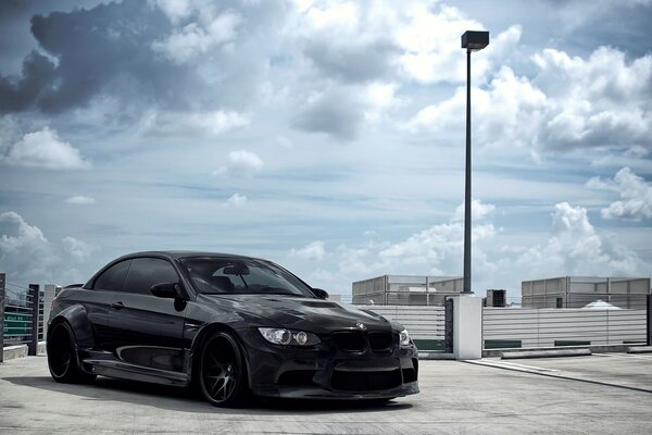 A black car is standing on the asphalt
