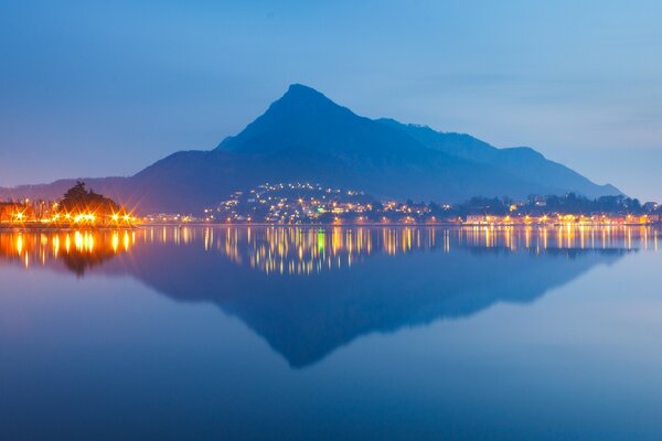Reflection of the mountain and the lights of the city in the water