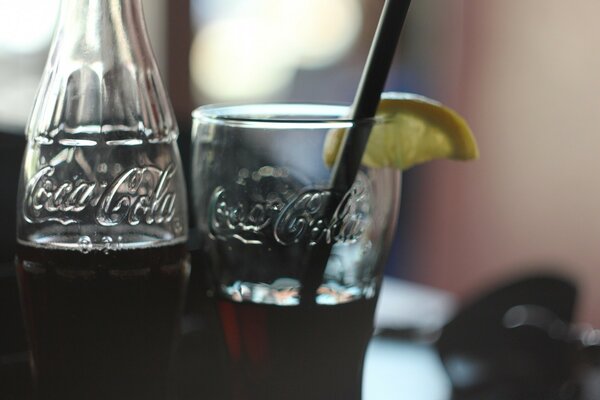 A bottle and a glass of Coca Cola