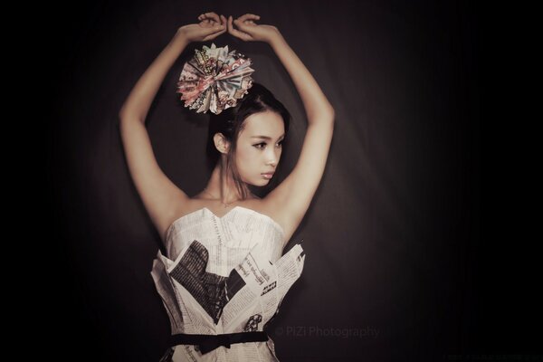 A model in a newspaper dress. Dark background