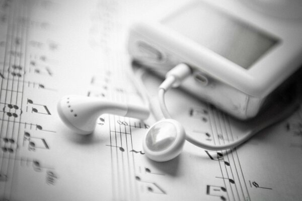 Headphones with a player on sheet music