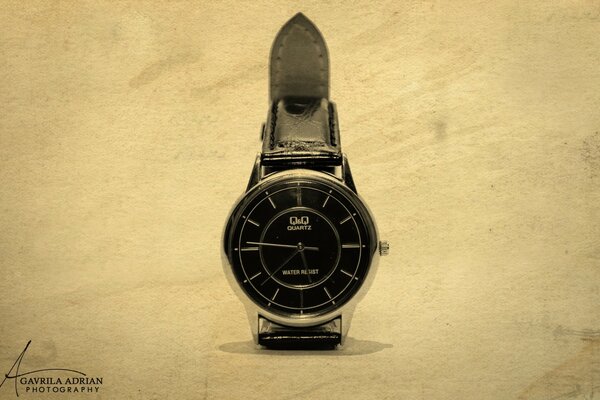 Watch with black dial and strap on a light background