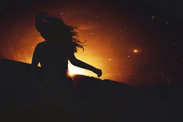 Dark silhouette of a girl at sunset
