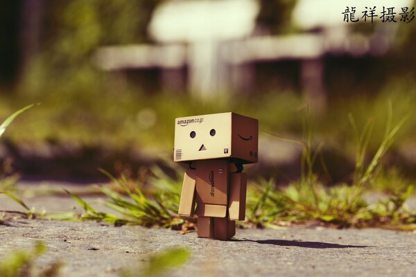 A small robot made of paper on asphalt