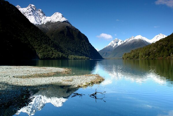 A lake, and around the mountains with the tops of snow