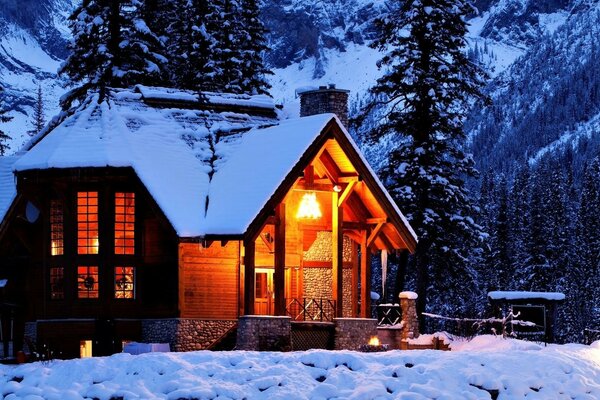 A house in the snowy mountains of the winter forest