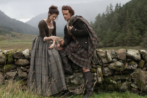 A man and a woman from the old time on a landscape background