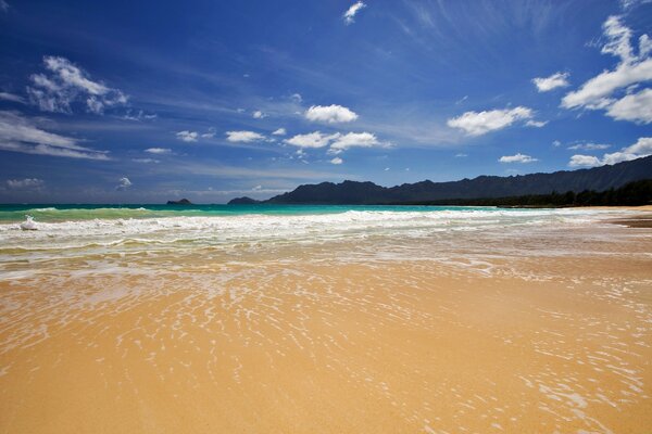 Sandy beach on the background of blue sky