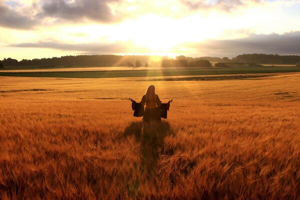 A happy woman in a golden field of wheat