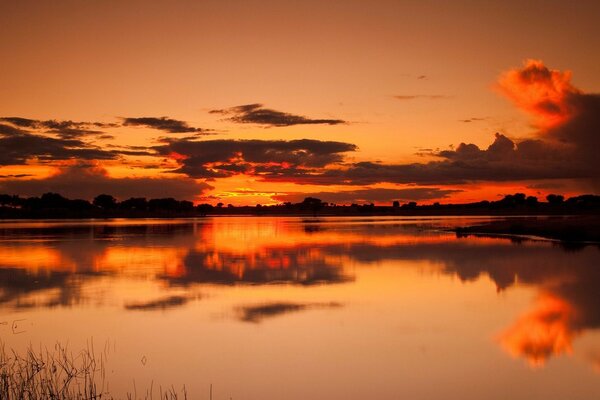 Beautiful sunset view on the lake in orange colors