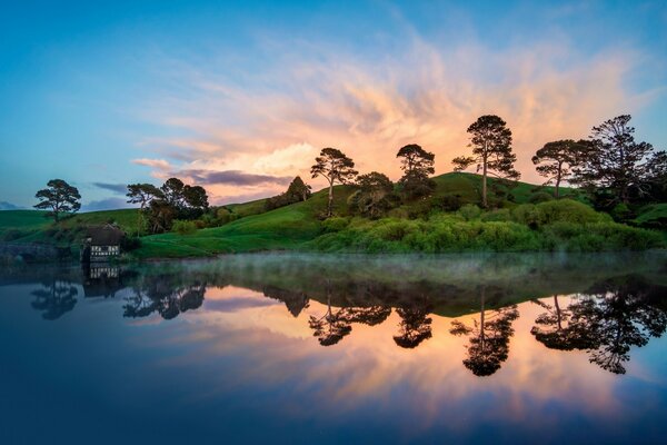 The sun rises against the background of green nature and water