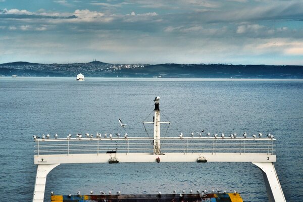 Photo of the sea from a ship with mountains in the background